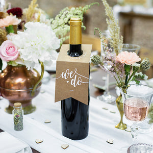 Kraft paper wedding bottle hangers with the words we do printed in white