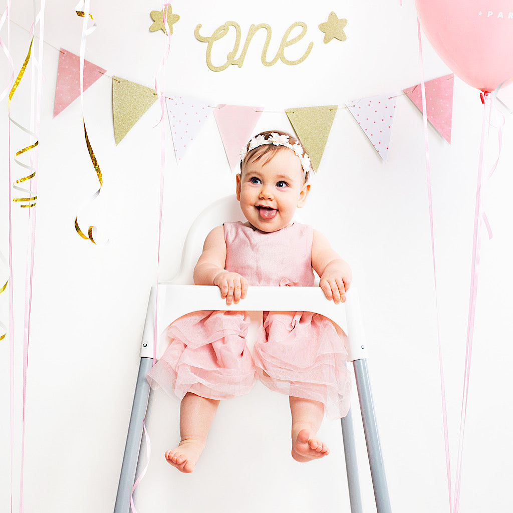 first birthday Gold sparkle banner with the words one cut out and gold stars either side