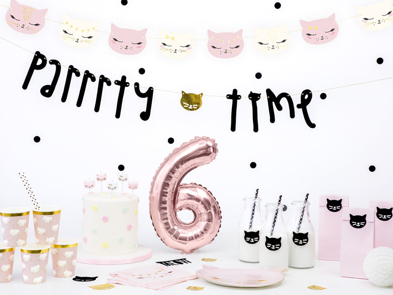pink and gold cat party decorations with cat face banners, cups, plates and party bags