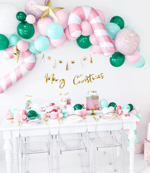 Christmas and new years eve decorations, with balloons, garlands, plates, cups and napkins. Including green, pink and gold decorations.