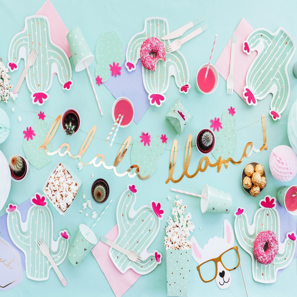 Boho Llama party decorations with gold llama garland, mint party cups with gold details, mint coloured cactus shaped plate with hot pink details, straws and napkins.
