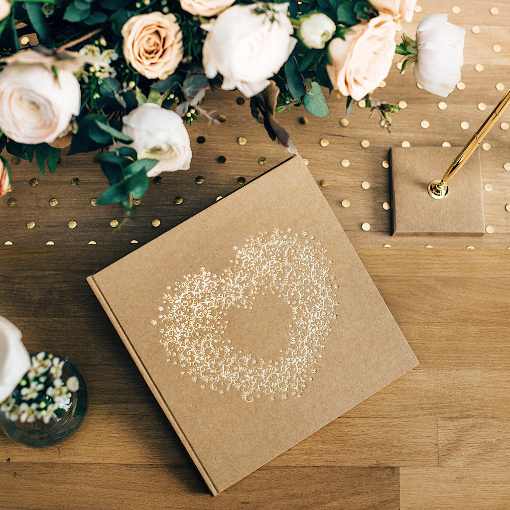 wedding guest book with gold foil heart print on brown kraft paper bound book with white pages to write in