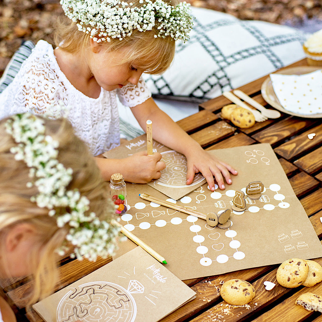 Children's wedding activity pack includes four book with various games on brown kraft paper with white print