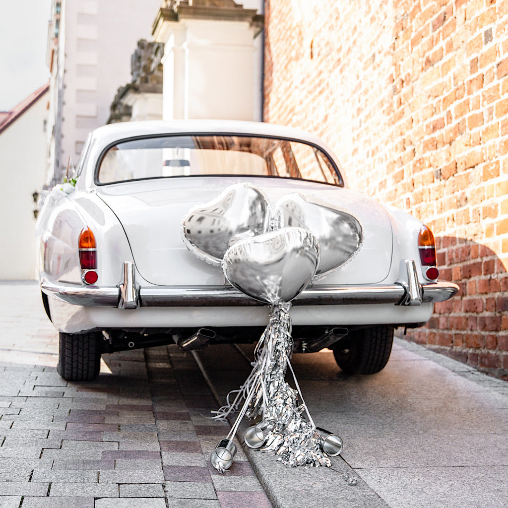 Wedding day car decoration kit with silver heart foil balloons, tassels and cans to decorate the back of the wedding car 