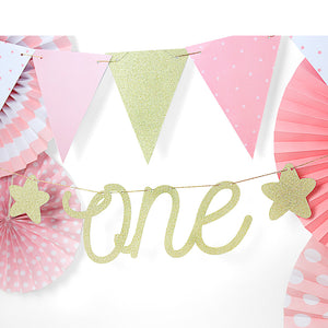 first birthday Gold sparkle banner with the words one cut out and gold stars either side