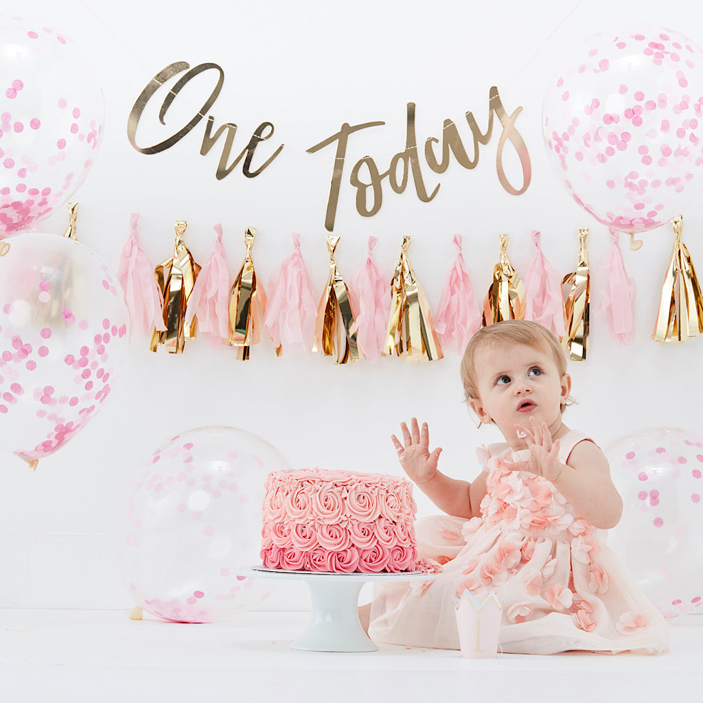 pink first birthday cake smash decorations kit. Includes one today gold banner, pink and gold tassle garland, pink confetti balloons and 1 gold foil party hat