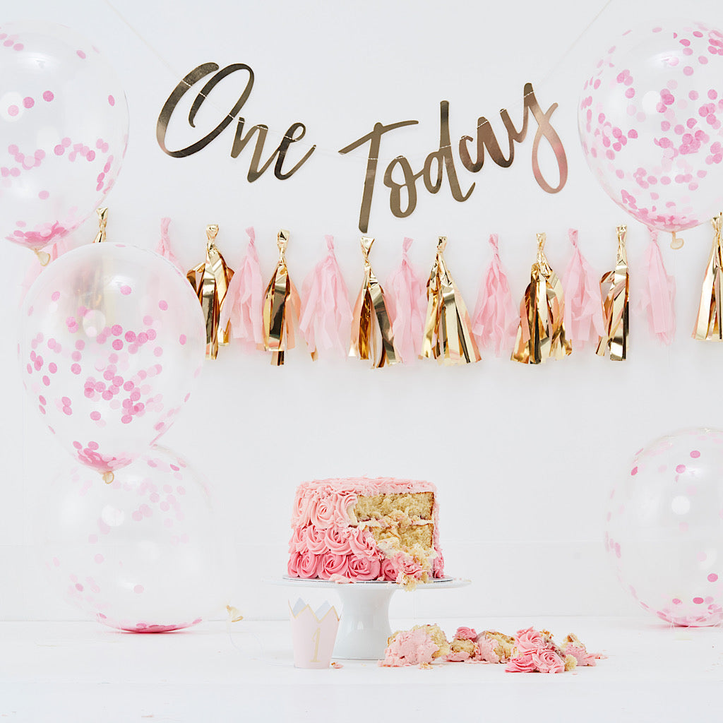 pink first birthday cake smash decorations kit. Includes one today gold banner, pink and gold tassle garland, pink confetti balloons and 1 gold foil party hat
